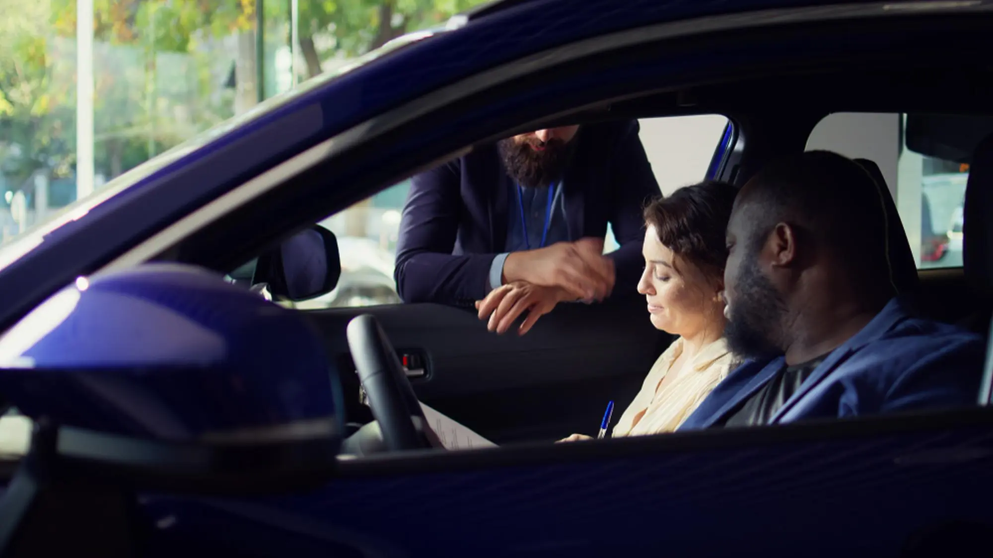Passenger sitting in a car while driver checks directions on a mobile device